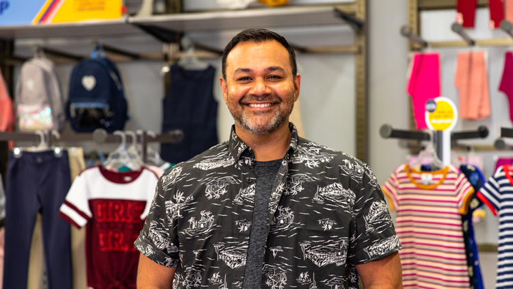 Old Navy Employee Standing in Front of Merchandise 